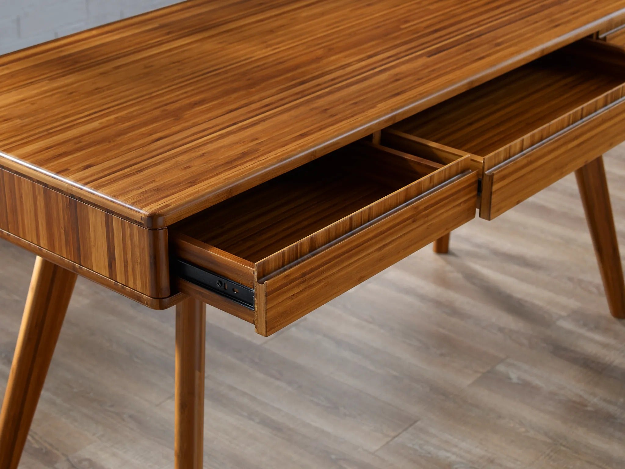 A renewable Currant Bamboo Writing Desk by Greenington, in amber color with a detailed view of the open drawer.