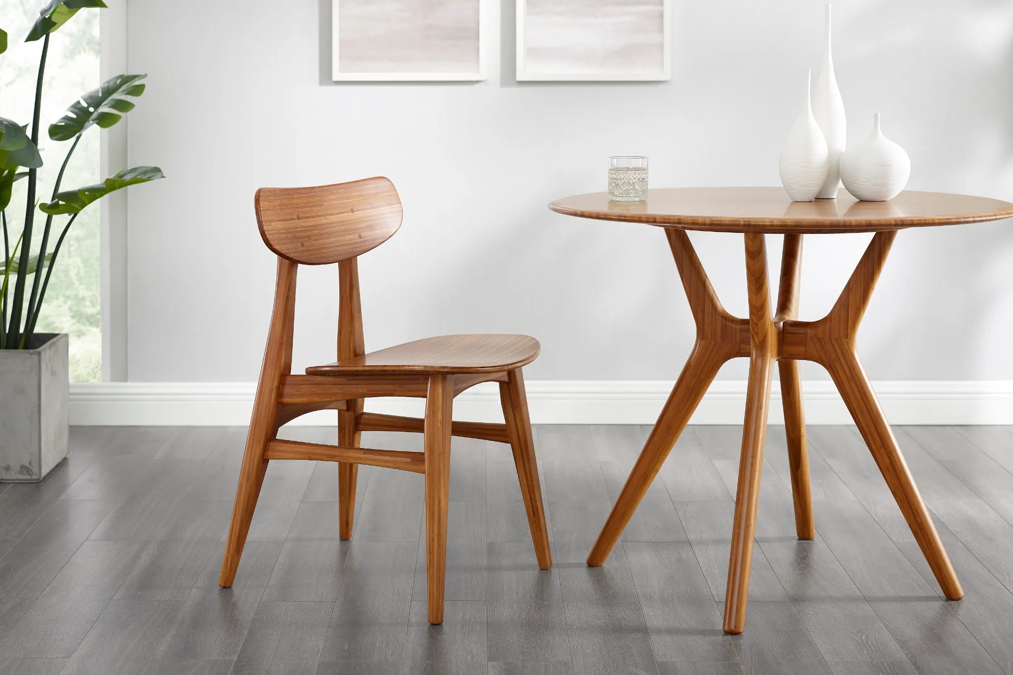 A Cassia Bamboo Dining Chair by Greenington in amber color, around a matching dining table in a modern bright dining room.