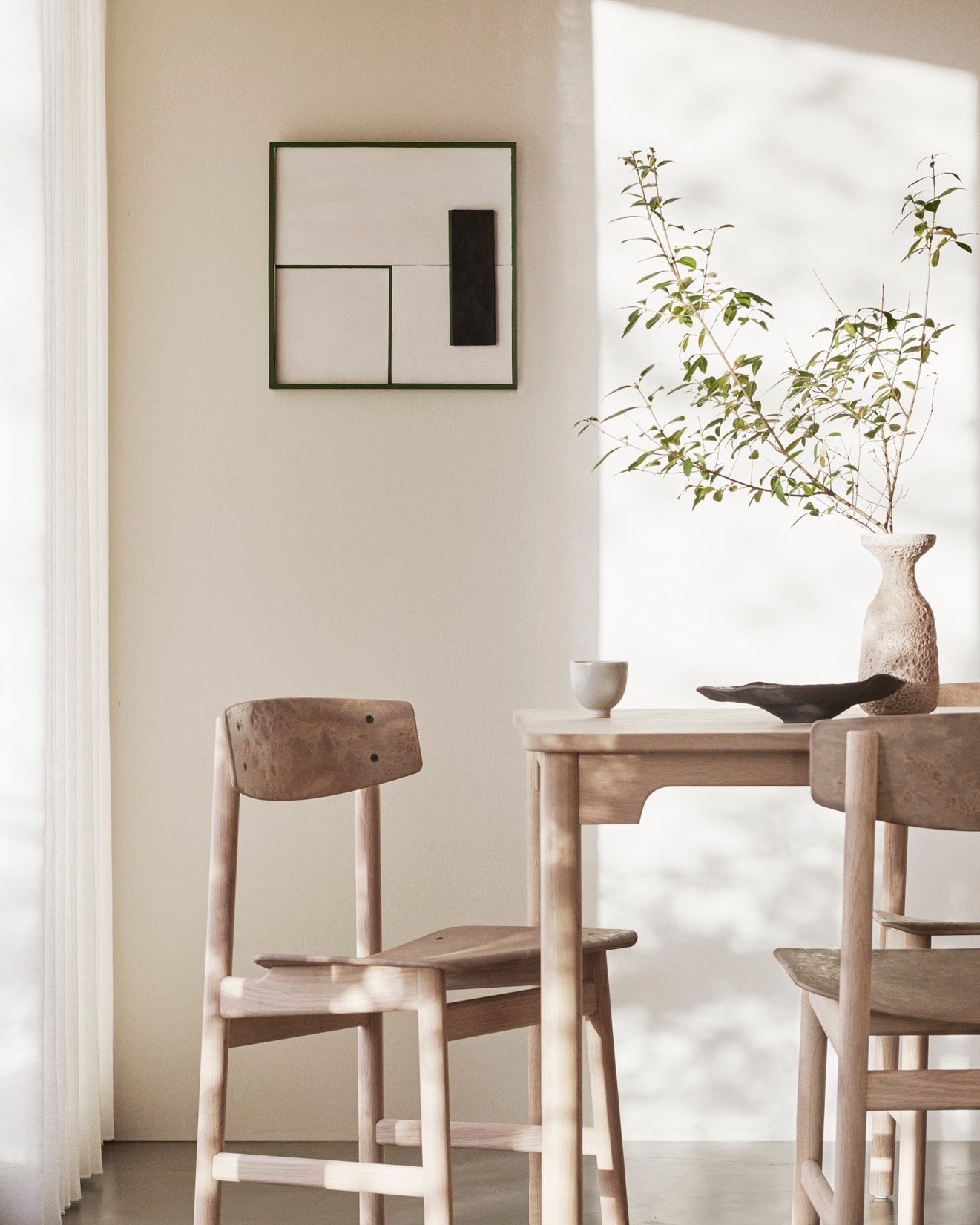 A sustainable Conscious table made of FSC-certified wood by Mater, with a Conscious chair in the shade of light.